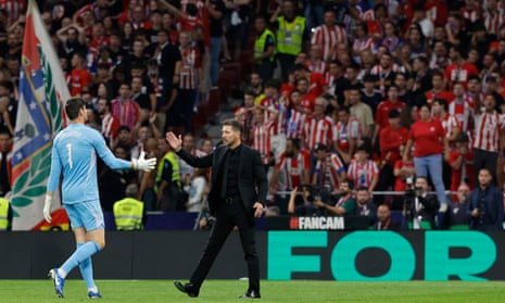 Thibaut Courtois and Diego Simeone, the Atlético Madrid manager, shake hands amid the disturbance to the derby.