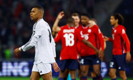 Kylian Mbappé walks off disconsolately while the Lille players celebrate their shock victory over Real Madrid.