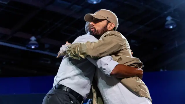 Eminem hugs former U.S. President Barack Obama during a campaign event for Democratic presidential nominee and U.S. Vice President Kamala Harris, during the first week of early voting in Detroit, Michigan