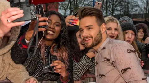 BBC A man is taking pictures with fans at an awards show