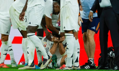 Dani Carvajal sits on the ground after his knee injury late in the match