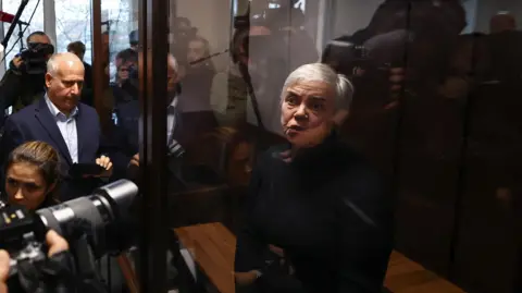 Reuters Nadezhda Buyanova, a 68-year-old paediatrician denounced by a patient's mother for an alleged unpatriotic statement and accused of blaming Russia's armed forces for a military conflict against Ukraine, stands inside an enclosure for defendants during a court hearing in Moscow, Russia