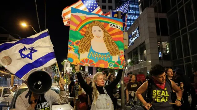 Protesters wave an Israeli flag and an American flag, and one holds a painted portrait