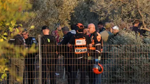 AFP Israeli first responders and security forces in an olive grove near Haifa, northern Israel, where a Hezbollah rocket attack killed two people (31 October 2024)