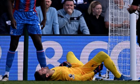 Alisson lies on the turf and holds his hamstring after suffering his latest injury setback in Liverpool’s win at Selhurst Park