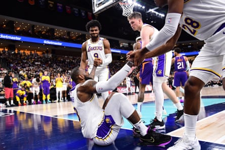 LeBron James is helped up by Bronny James and fellow teammates.