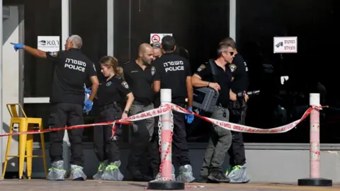 Reuters A contingent of Israeli police pictured at the scene of an attack in Beersheba, southern Israel on 6 October